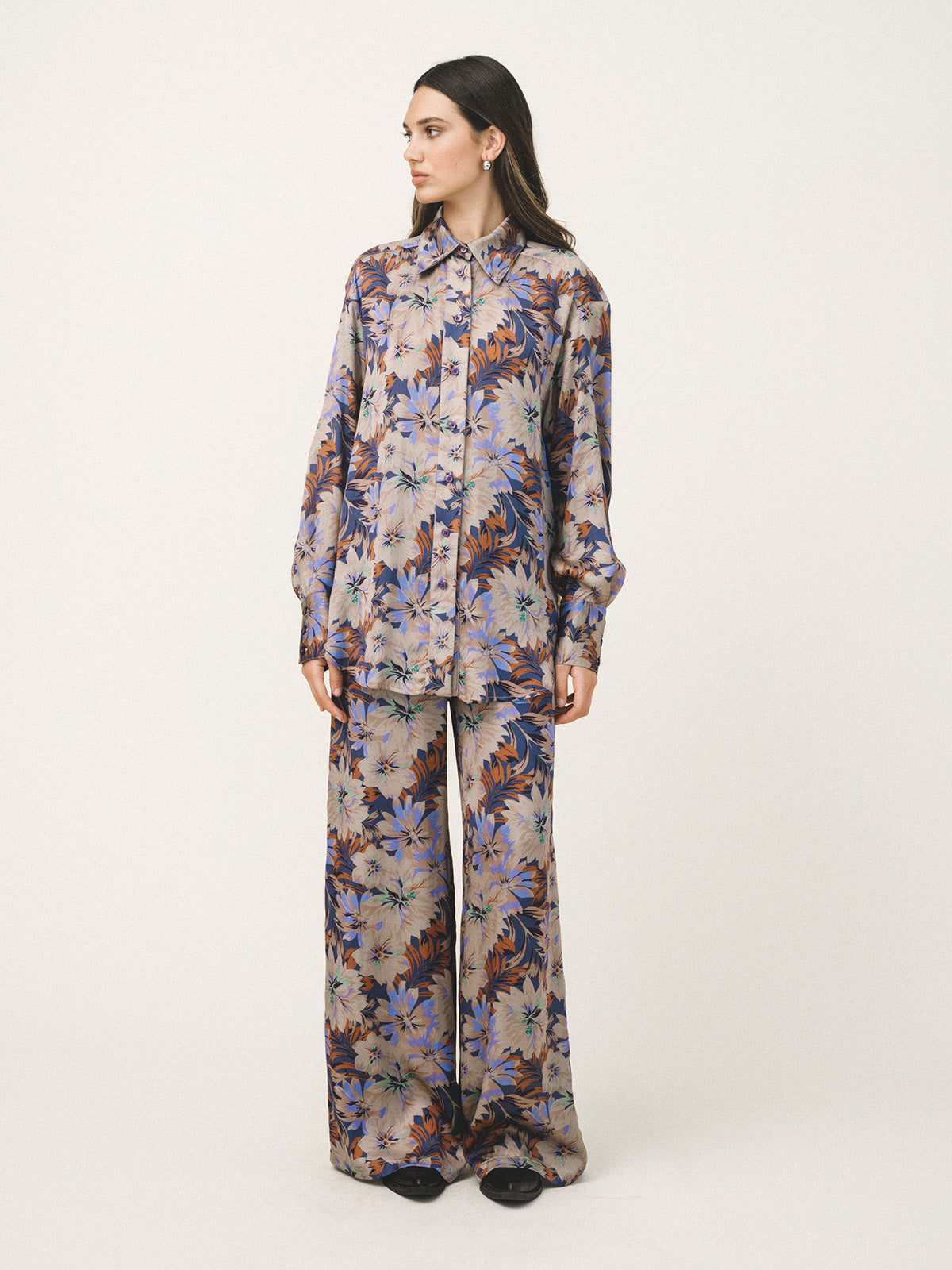 Woman wearing a floral patterned outfit on a white background