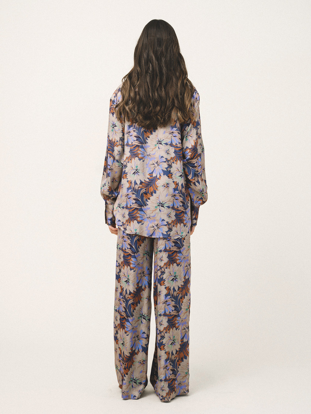 Person wearing a floral pajama set on a white background