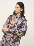 Woman wearing a floral patterned dress against a plain background