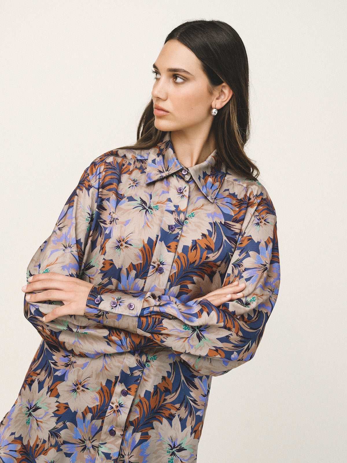Woman wearing a floral patterned dress against a plain background