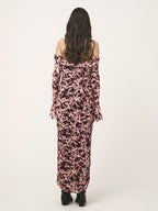 Woman wearing a pink floral off-shoulder dress on a white background