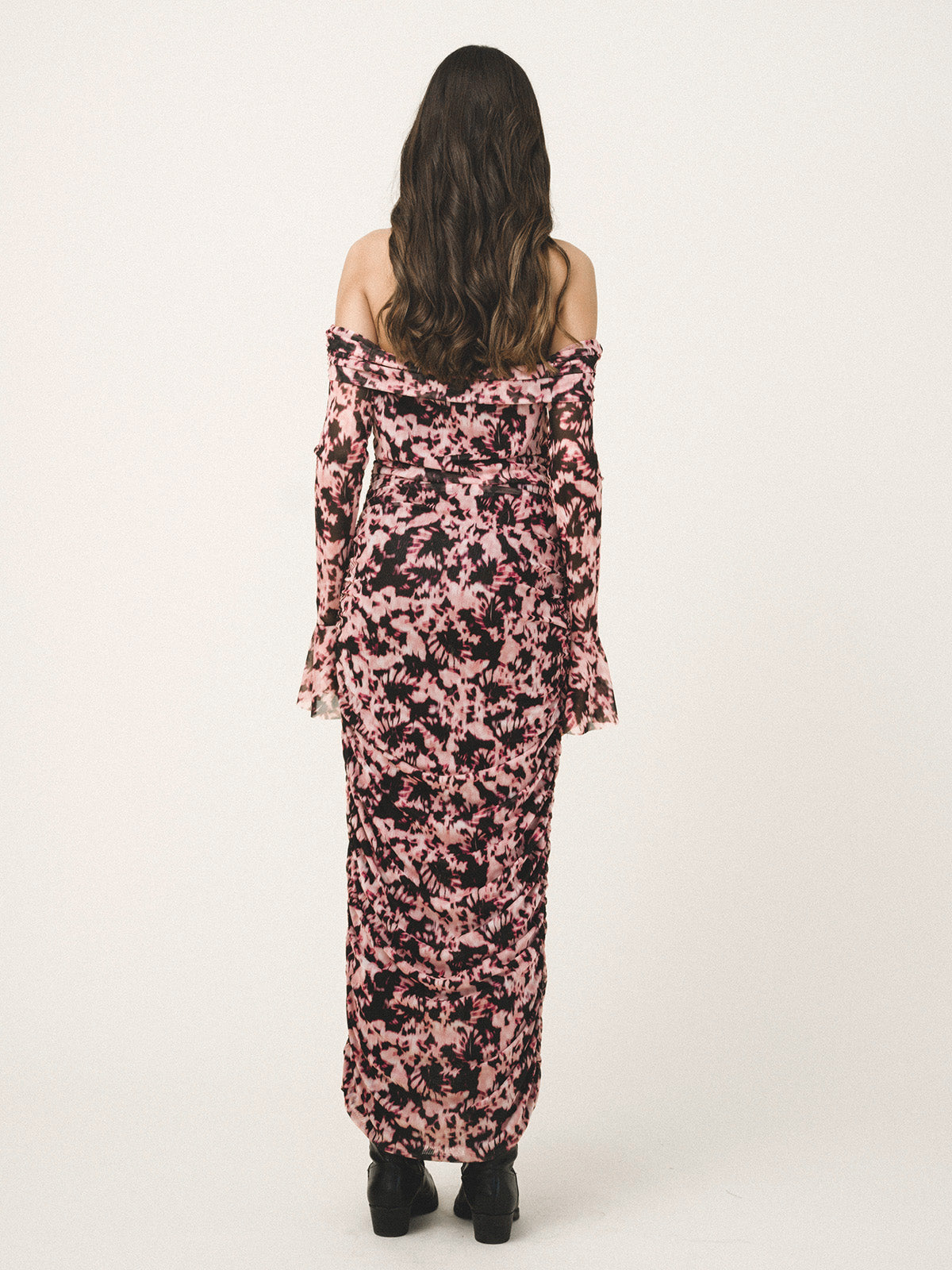 Woman wearing a pink floral off-shoulder dress on a white background