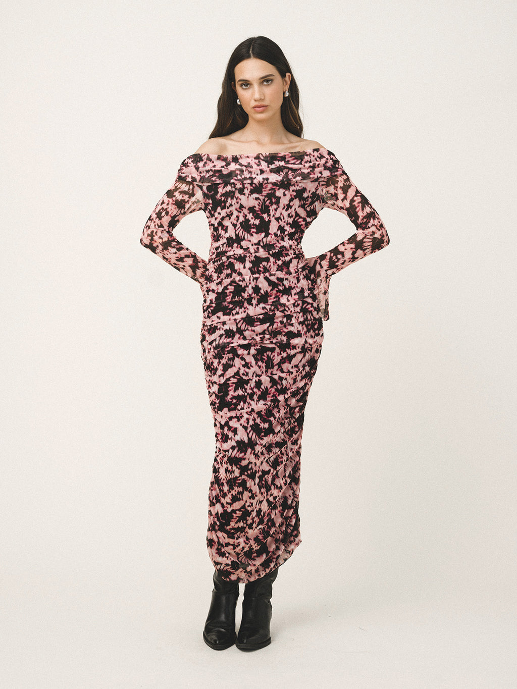 Woman wearing a floral off-shoulder dress on a white background