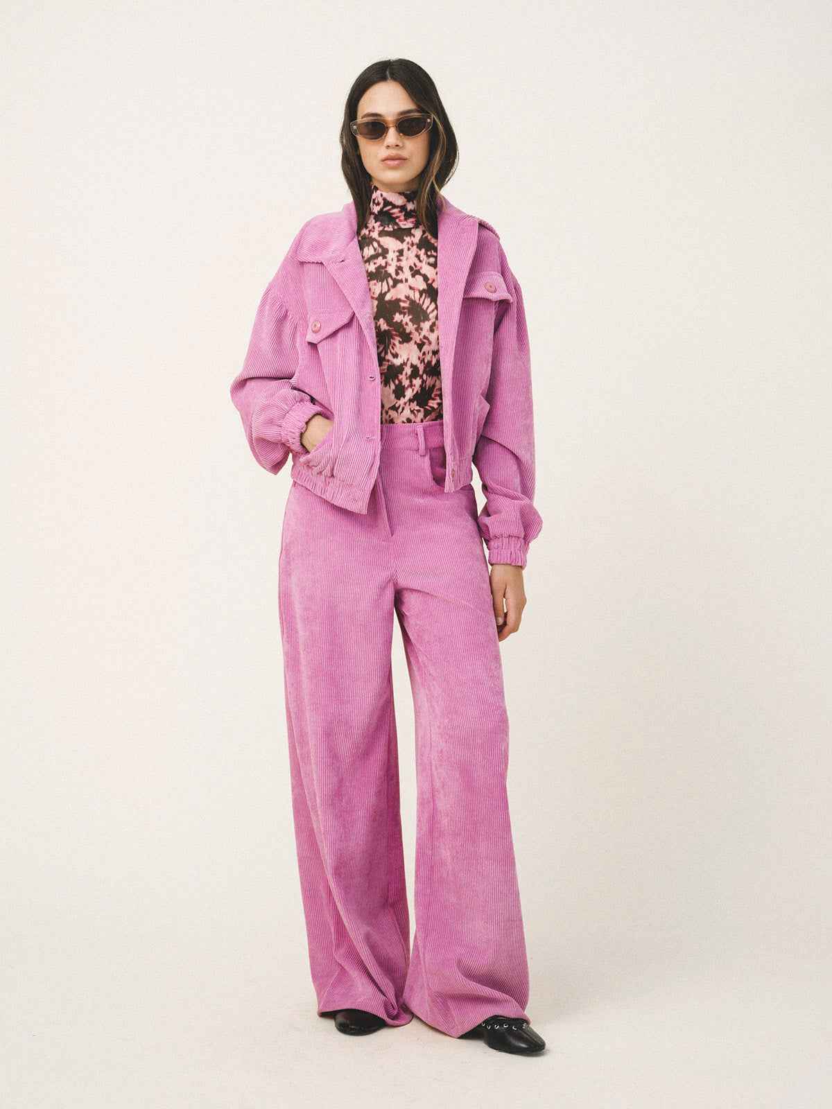 Person wearing a pink outfit with a jacket and pants on a white background