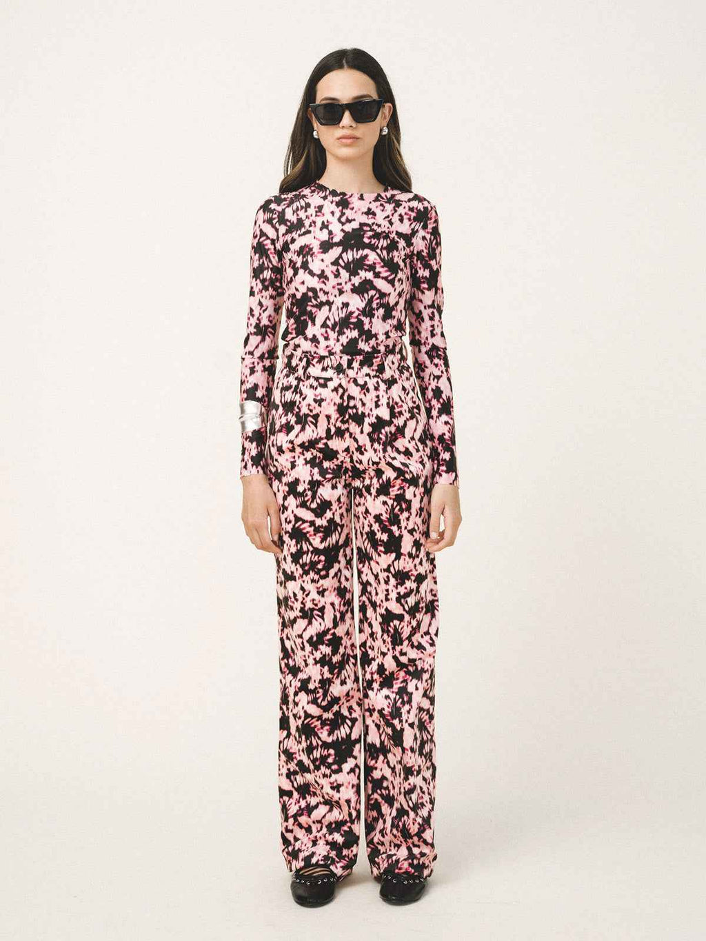 Woman wearing a pink and black patterned outfit on a white background