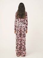 Person wearing a pink and black floral jumpsuit on a white background