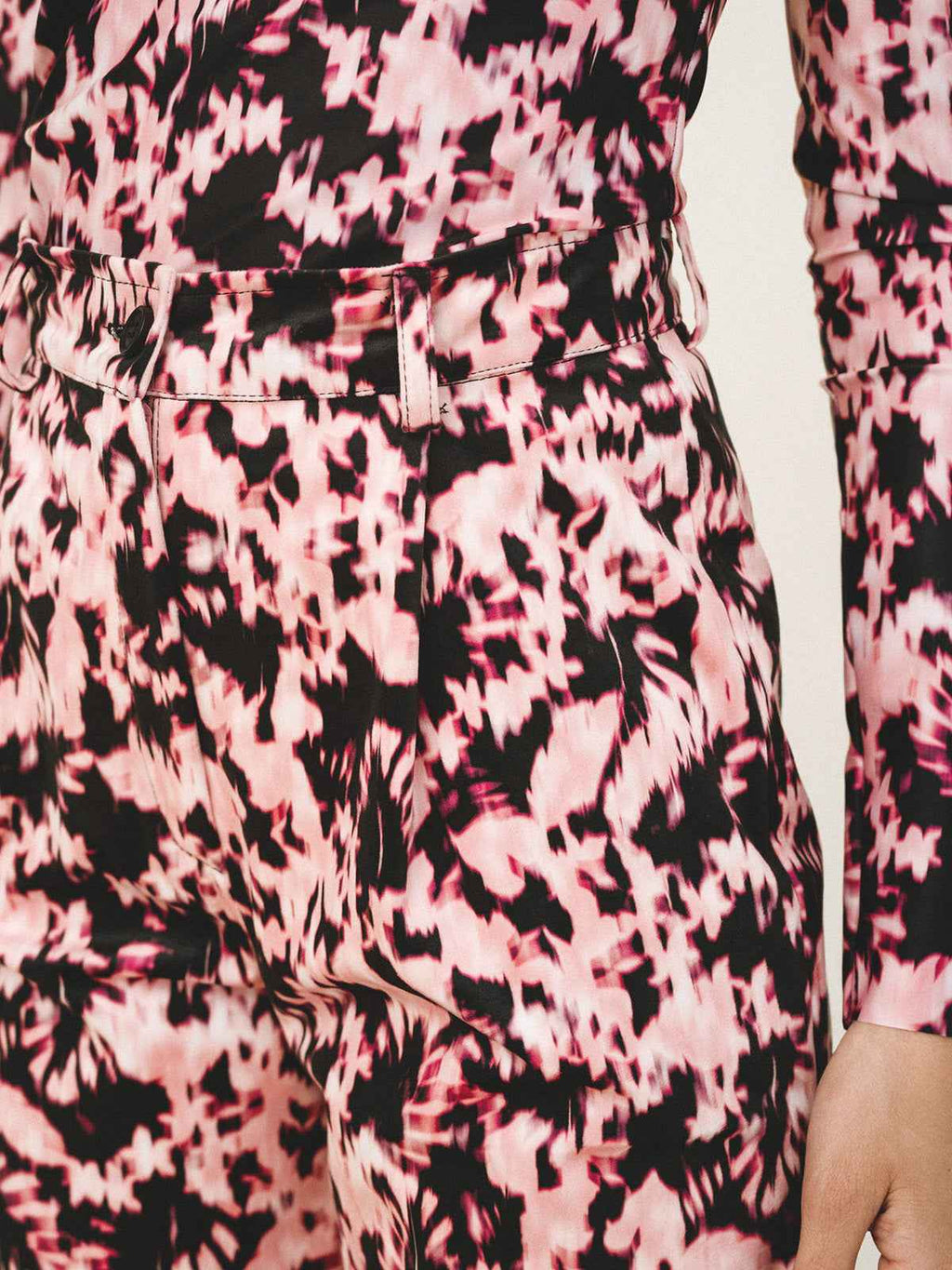 Close-up of a person wearing a pink and black patterned outfit.