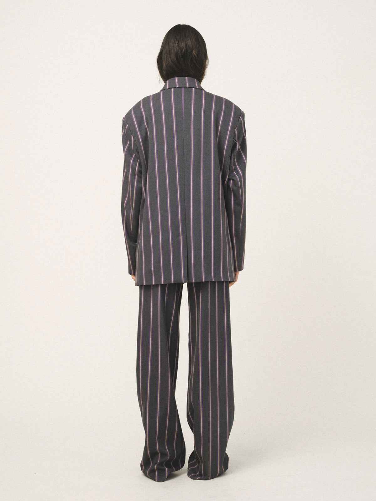 Person wearing a striped pajama set on a white background