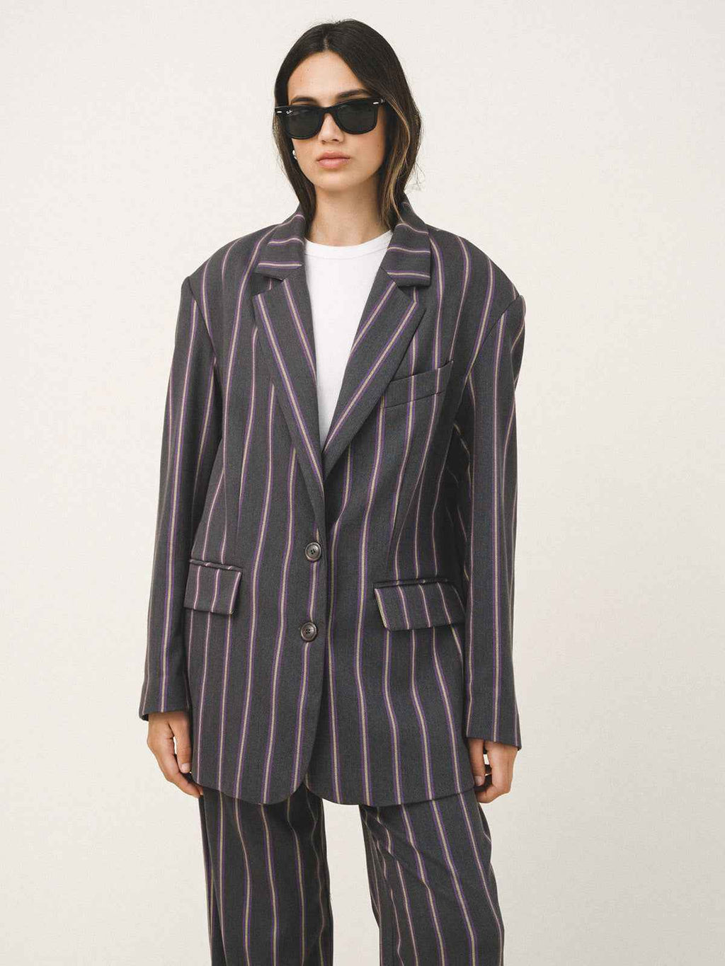 Person wearing a striped suit with sunglasses on a white background