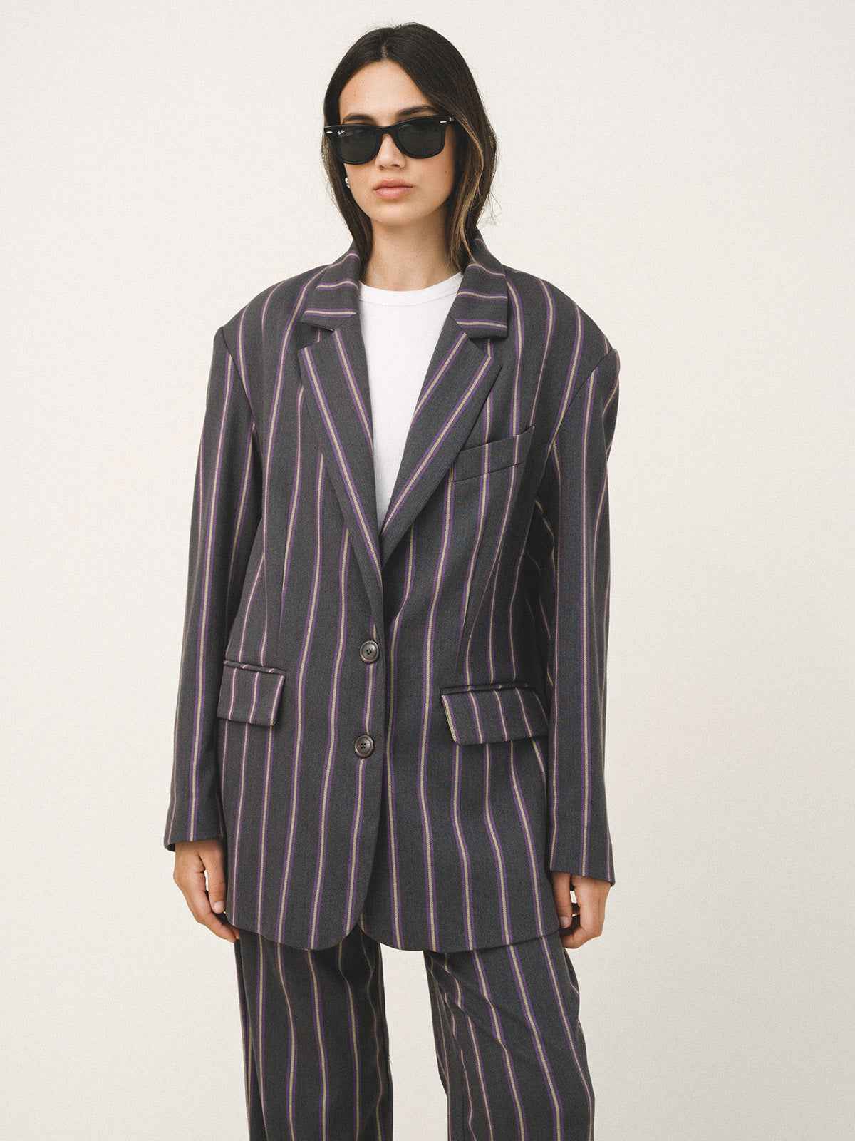 Person wearing a striped suit with sunglasses on a white background