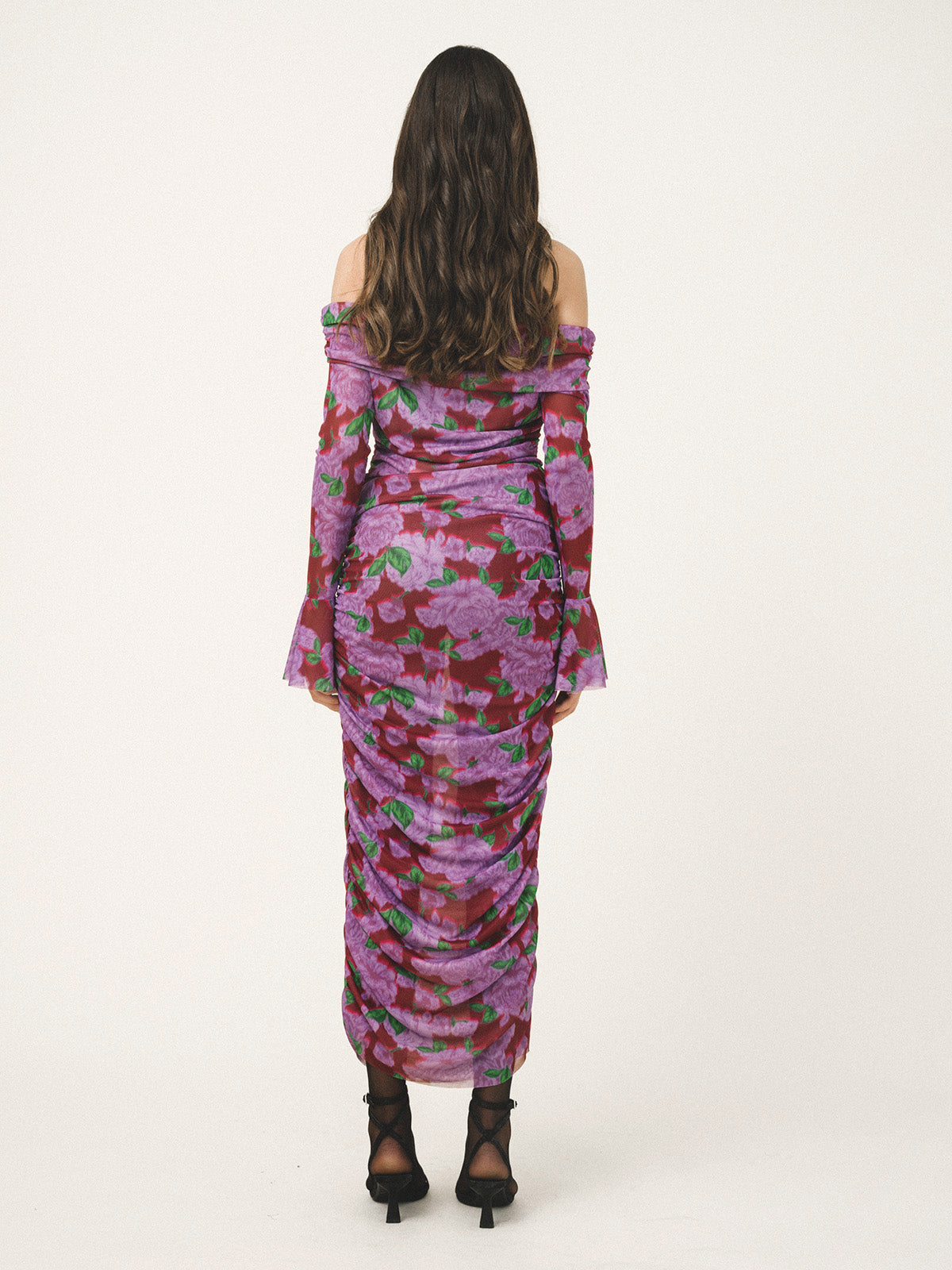 Woman wearing a floral off-shoulder dress on a white background
