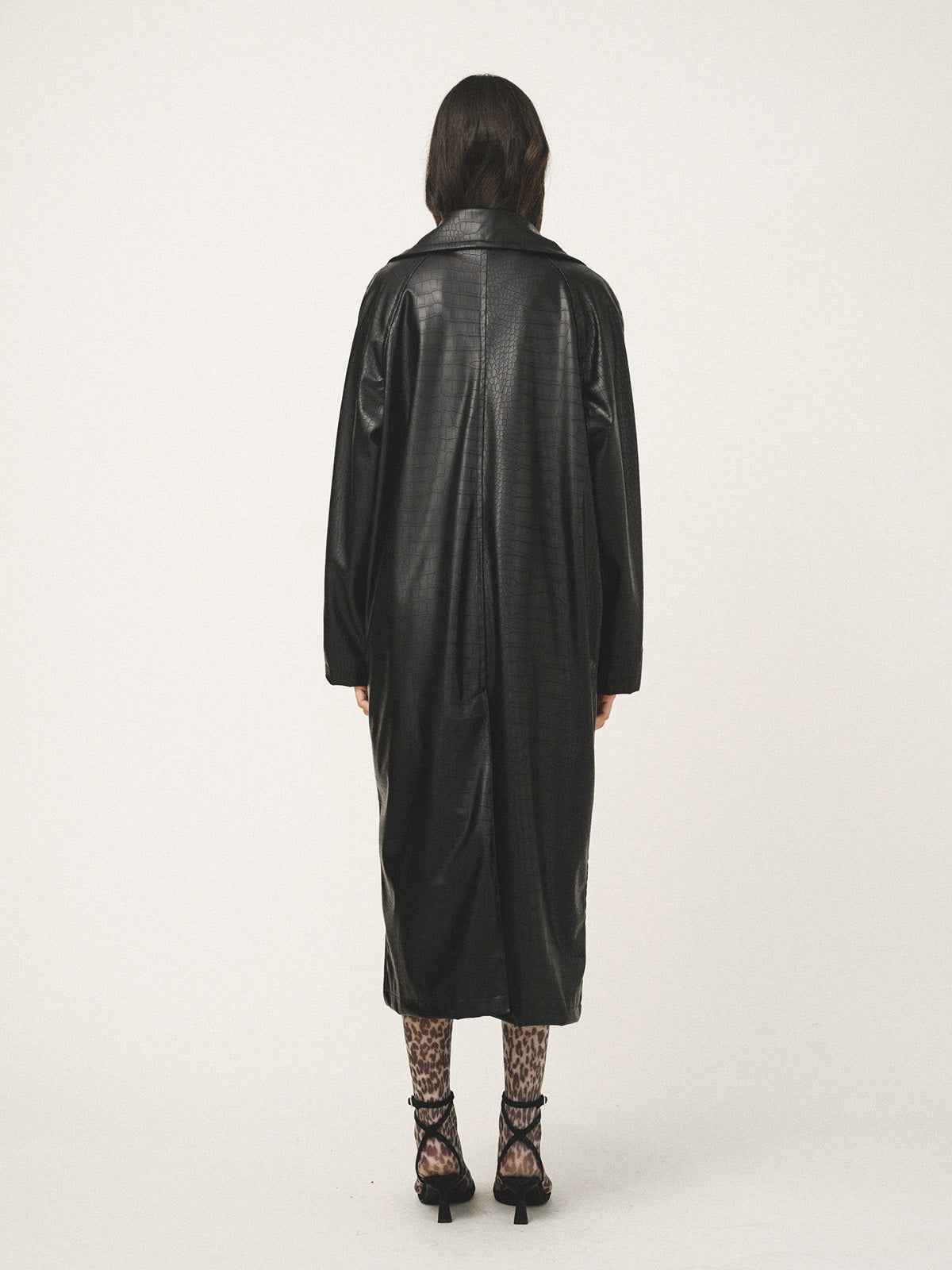 Person wearing a black leather coat on a white background