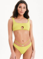 Woman wearing a yellow bikini set on a white background