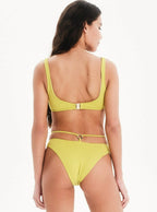 Woman wearing a yellow bikini set on a white background