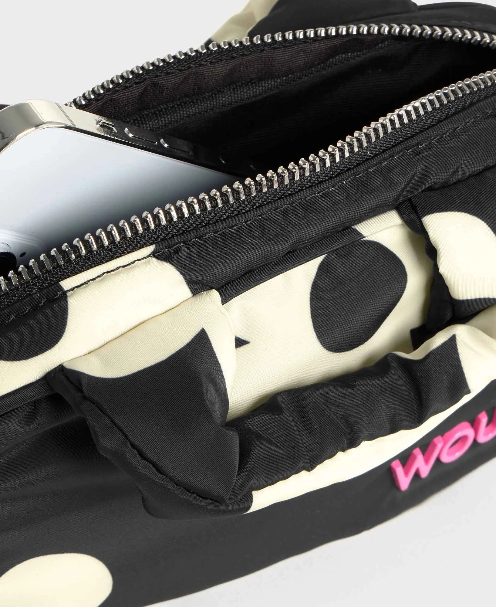 Black and white polka dot bag with a pink logo on a light gray background