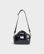 Black handbag with a visible brand logo on a light gray background