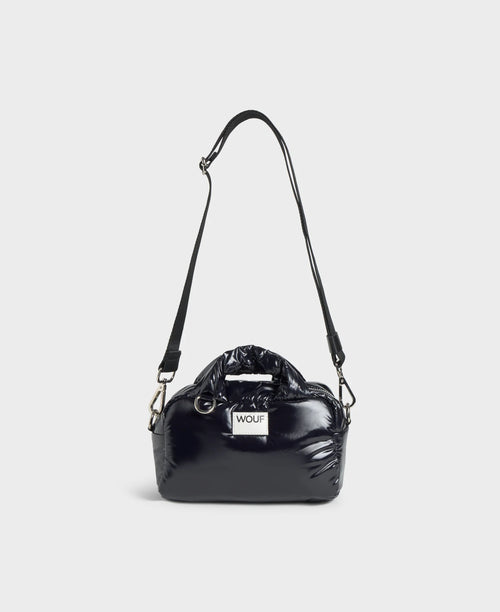 Black handbag with a visible brand logo on a light gray background
