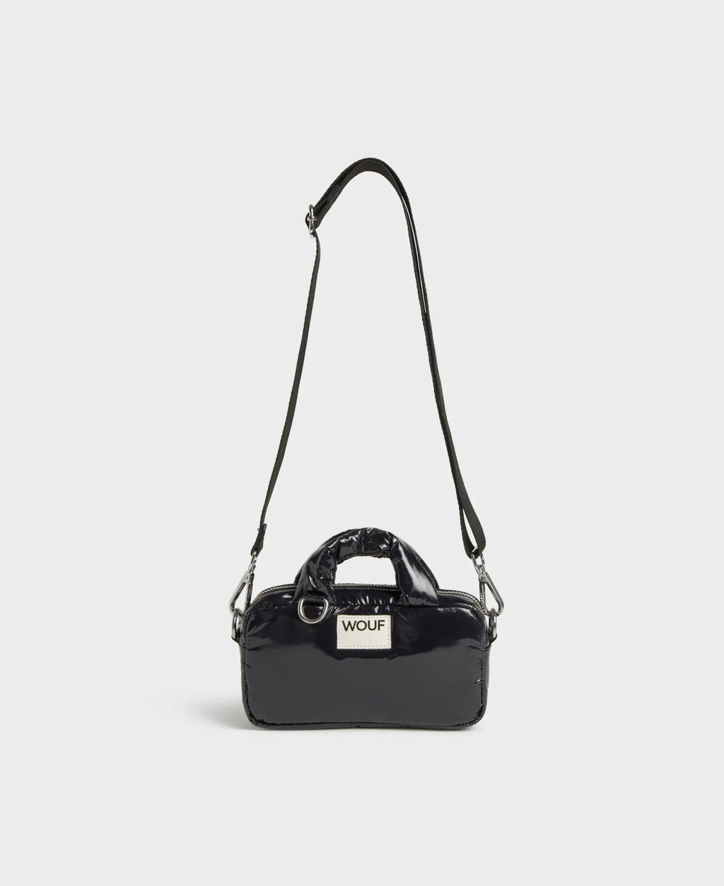 Black handbag with a visible brand label on a light gray background