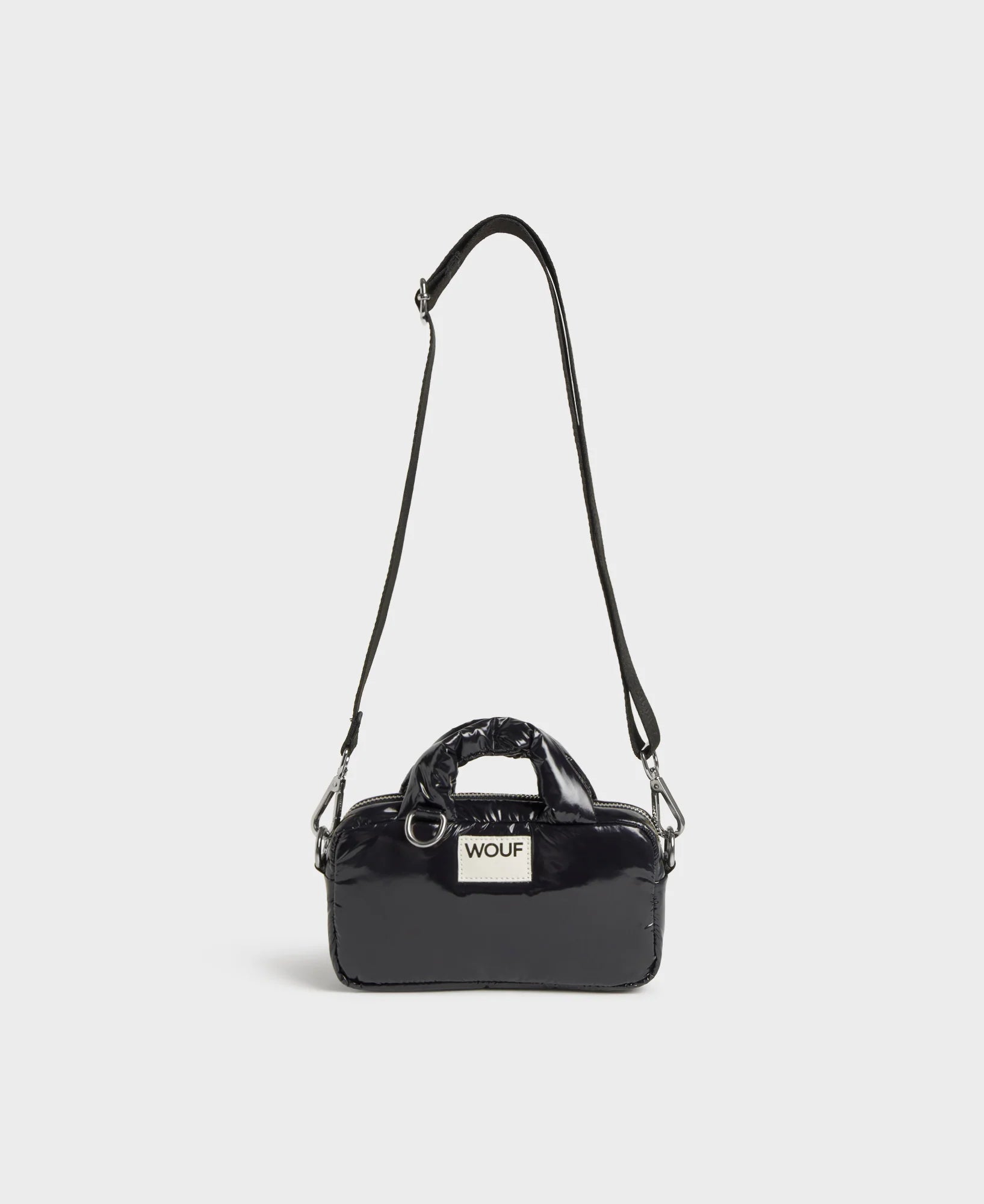 Black handbag with a visible brand label on a light gray background