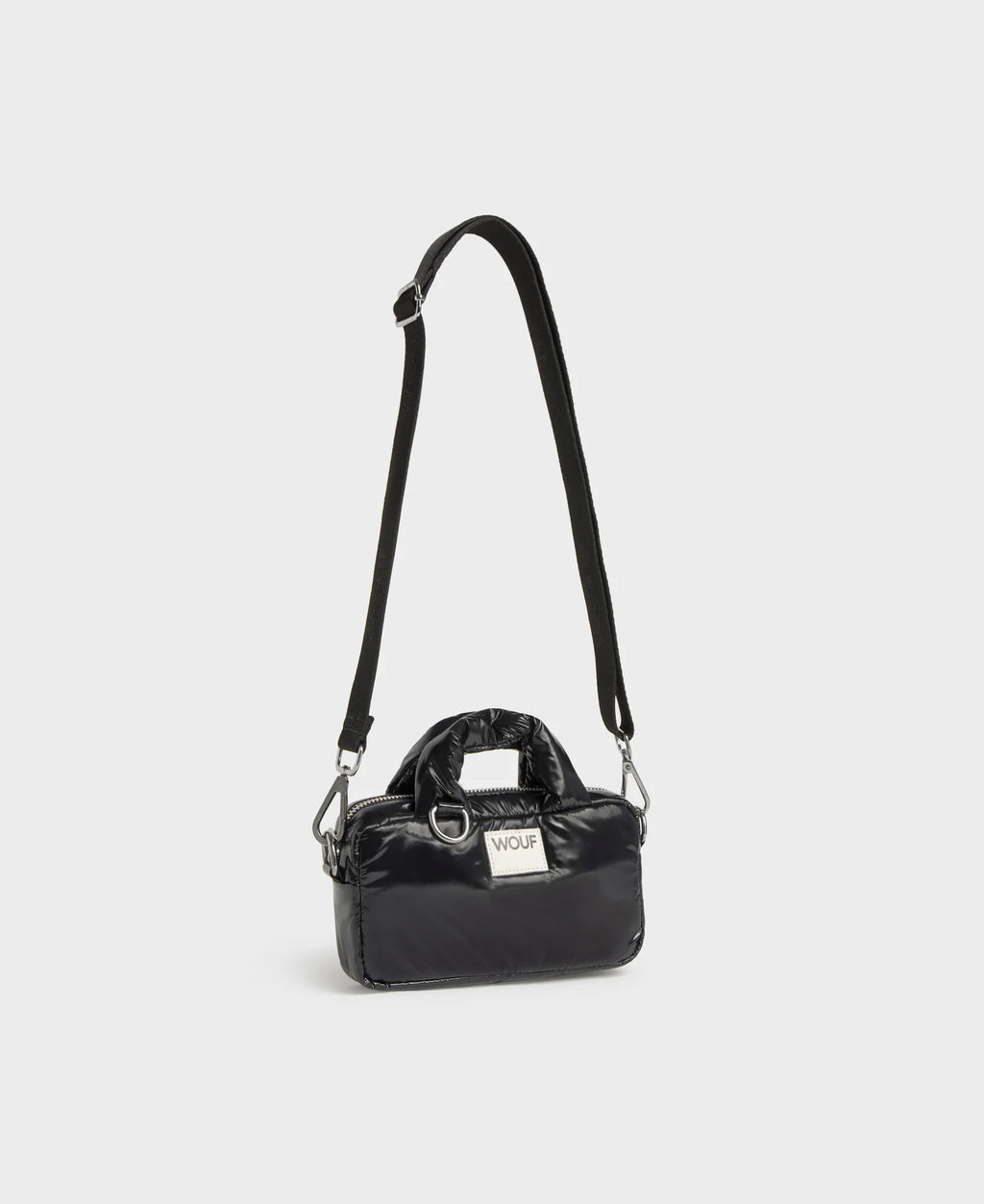 Black handbag with a strap on a light gray background