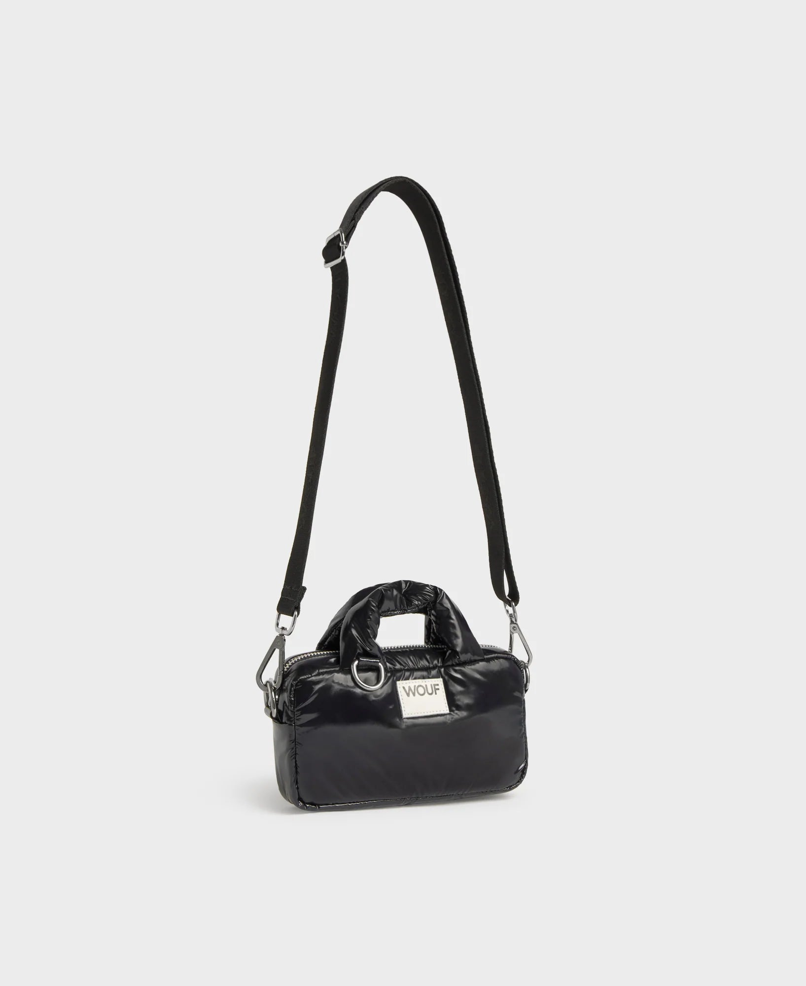 Black handbag with a strap on a light gray background