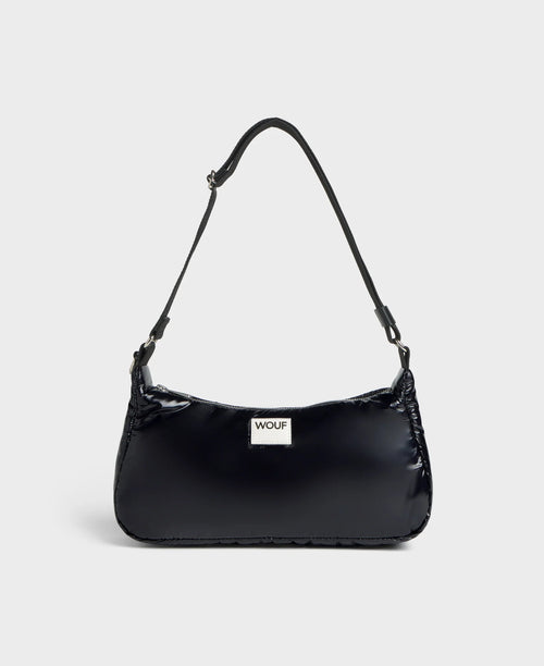 Black handbag with a visible brand logo on a light gray background