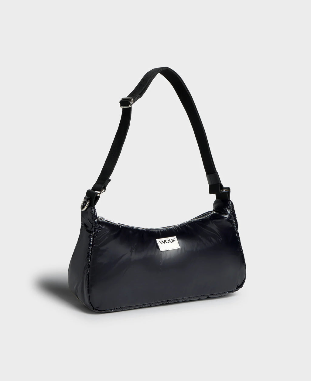 Black handbag with a strap on a light gray background