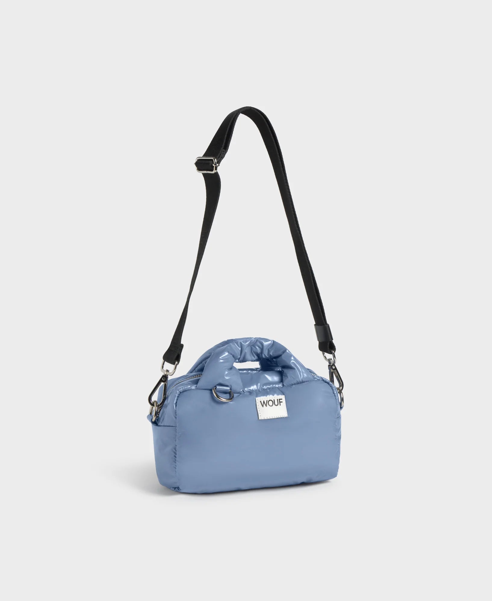 Blue bag with a black strap on a light gray background