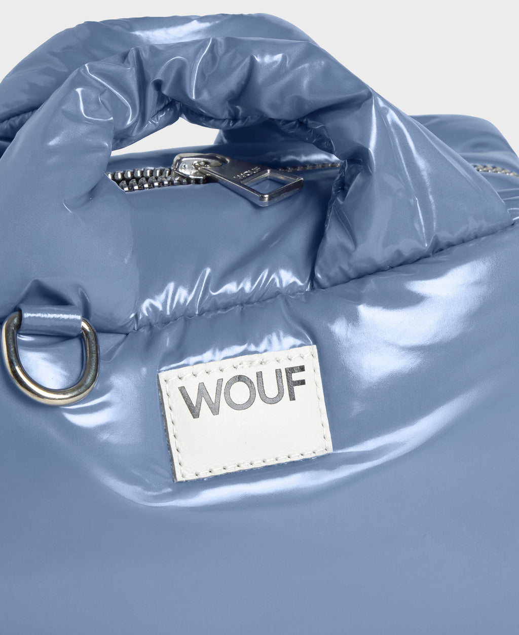 Shiny blue bag with a visible 'WOUF' brand label on a light gray background