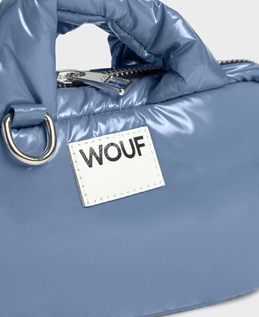 Blue puffer bag with a 'WOUF' label on a light gray background