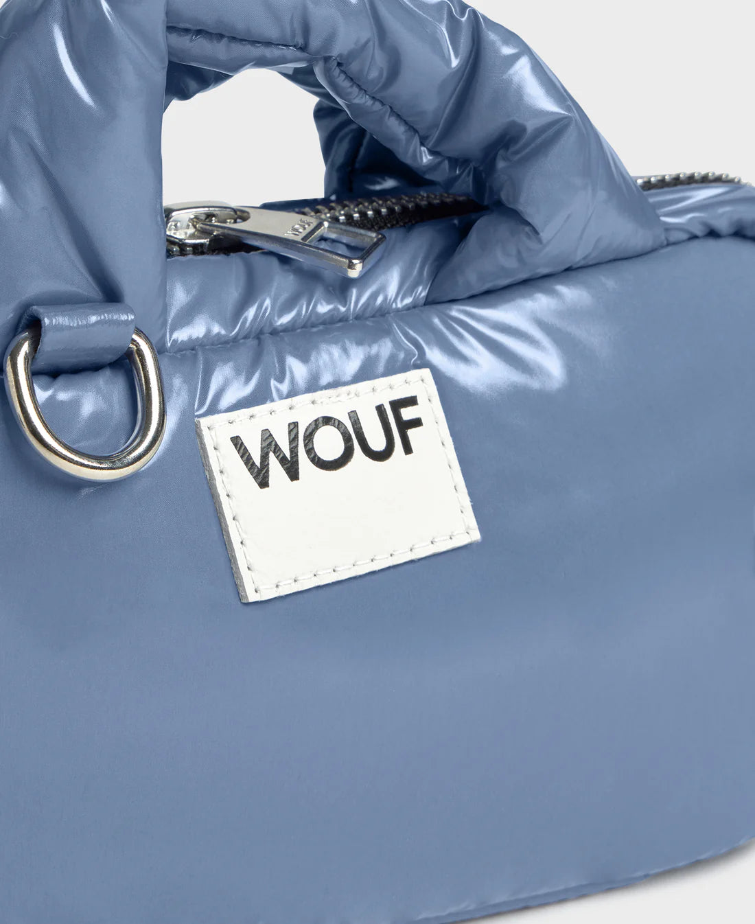 Blue puffer bag with a 'WOUF' label on a light gray background