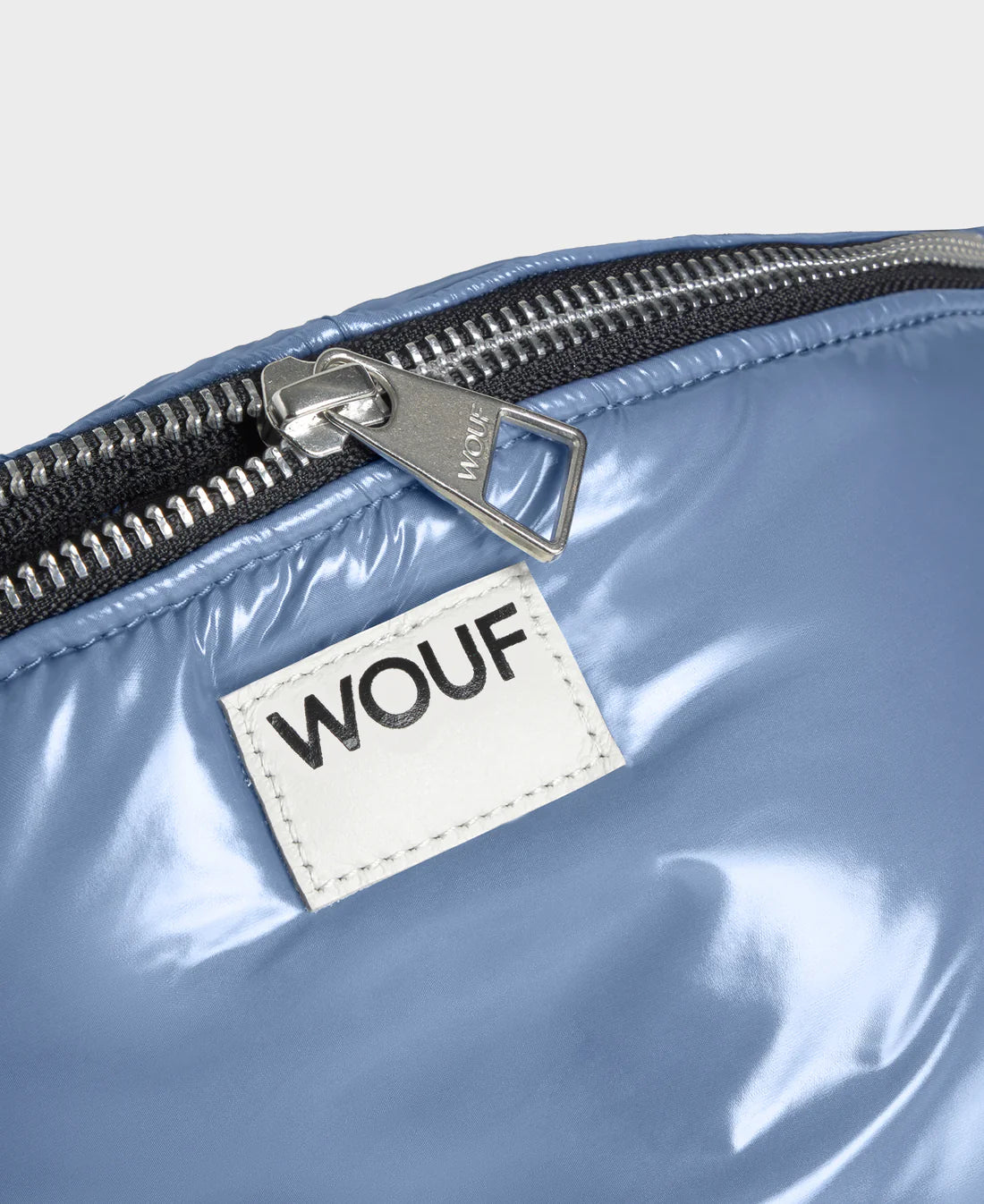 Blue bag with a WOUF label on a light gray background