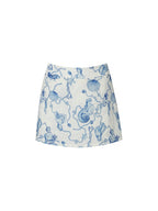 A white A-line mini skirt featuring a blue mermaid and seashell toile pattern, shown flat against a plain white background.