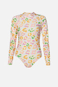 A long-sleeve bodysuit with a high mock neck, featuring an all-over pastel leopard print pattern in pink, yellow, green, and orange on a white base, shown against a light gray background.
