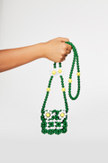 Hand holding a green beaded bag with floral design on a white background