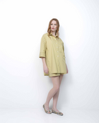 Woman wearing a yellow striped shirt and shorts on a white background