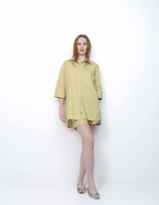 Woman wearing a yellow striped shirt dress on a white background