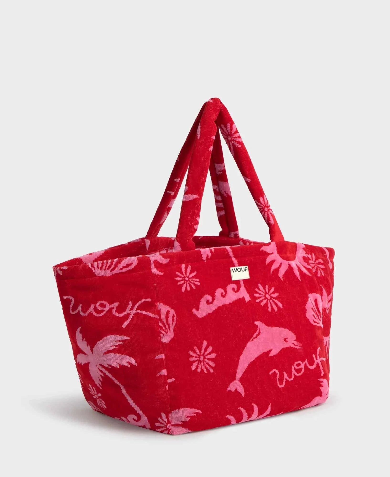 Red tote bag with pink dolphin and floral patterns on a white background