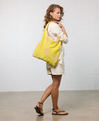 Woman holding a yellow tote bag with a white background