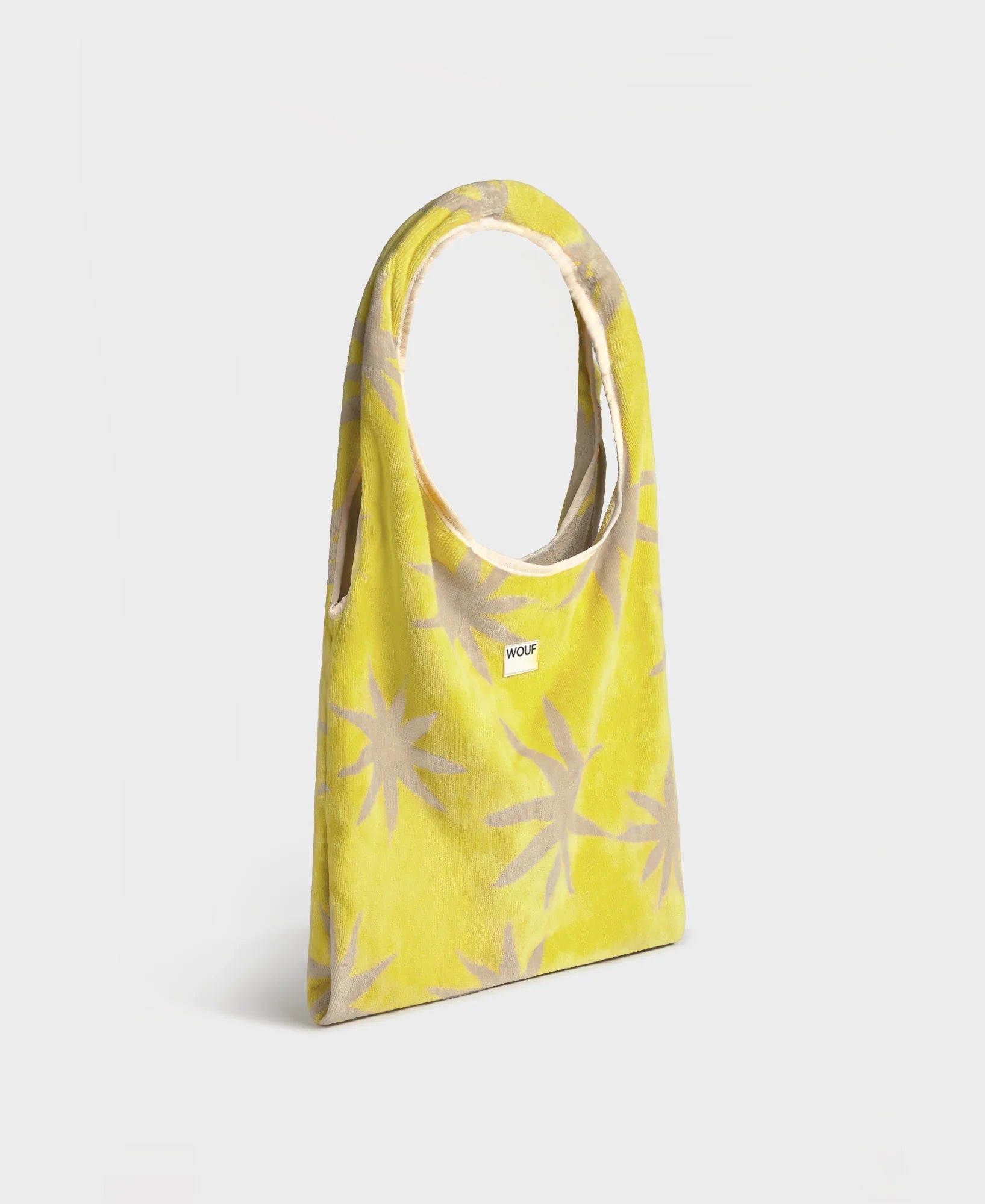 Yellow tote bag with beige star patterns on a light gray background
