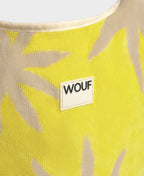 Yellow fabric with beige leaf patterns and a WOUF label.