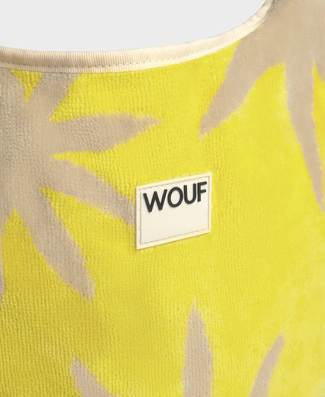 Yellow fabric with beige leaf patterns and a WOUF label.