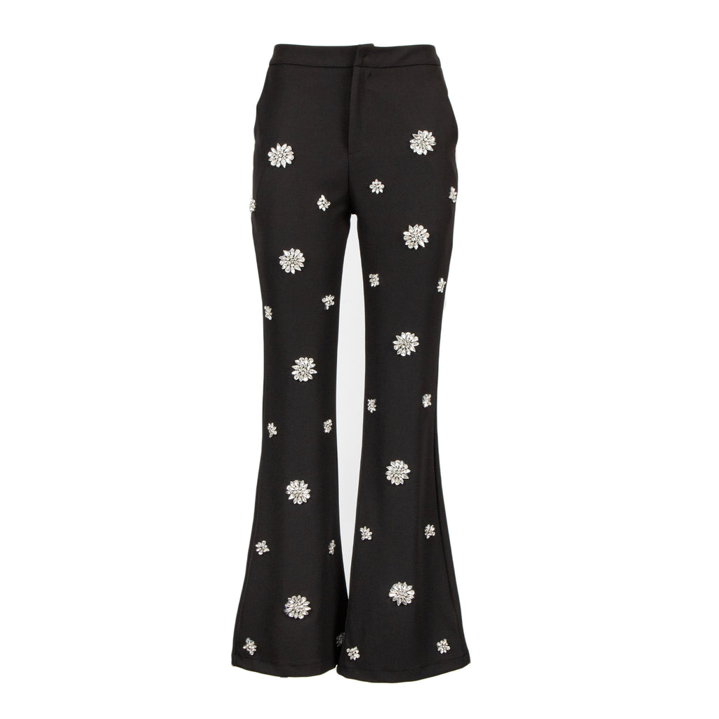 Black flared pants with white embroidered daisy patterns, shown against a plain white background.