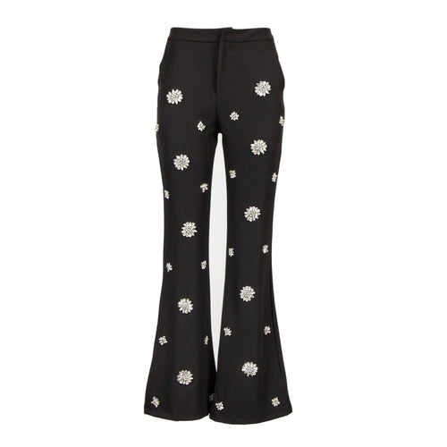 Black flared pants with white embroidered daisy patterns, shown against a plain white background.