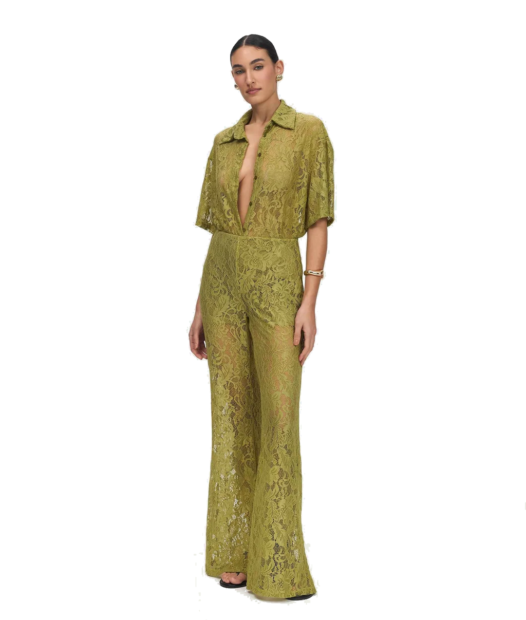 A woman modeling a matching olive green lace short-sleeve top and wide-leg pants set against a plain white background.