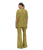 A woman shown from the back wearing a matching olive green lace two-piece set consisting of a short-sleeve collared top and flared pants, photographed against a plain white background.