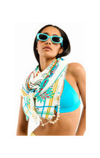 Woman wearing a colorful scarf and blue bikini top on a white background