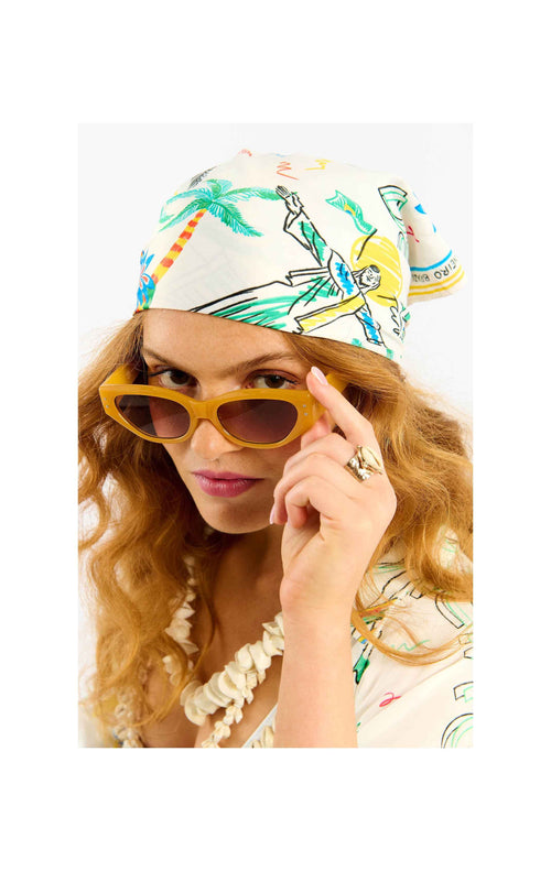 Person wearing a colorful headband with artistic designs and yellow sunglasses.