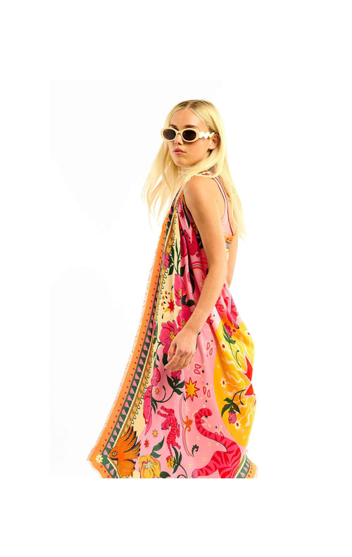 Woman wearing a colorful floral dress with a patterned scarf on a white background