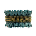 Green feathered bracelet with gold beads on a white background